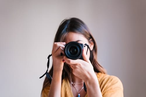 photographer woman at home holding a camera